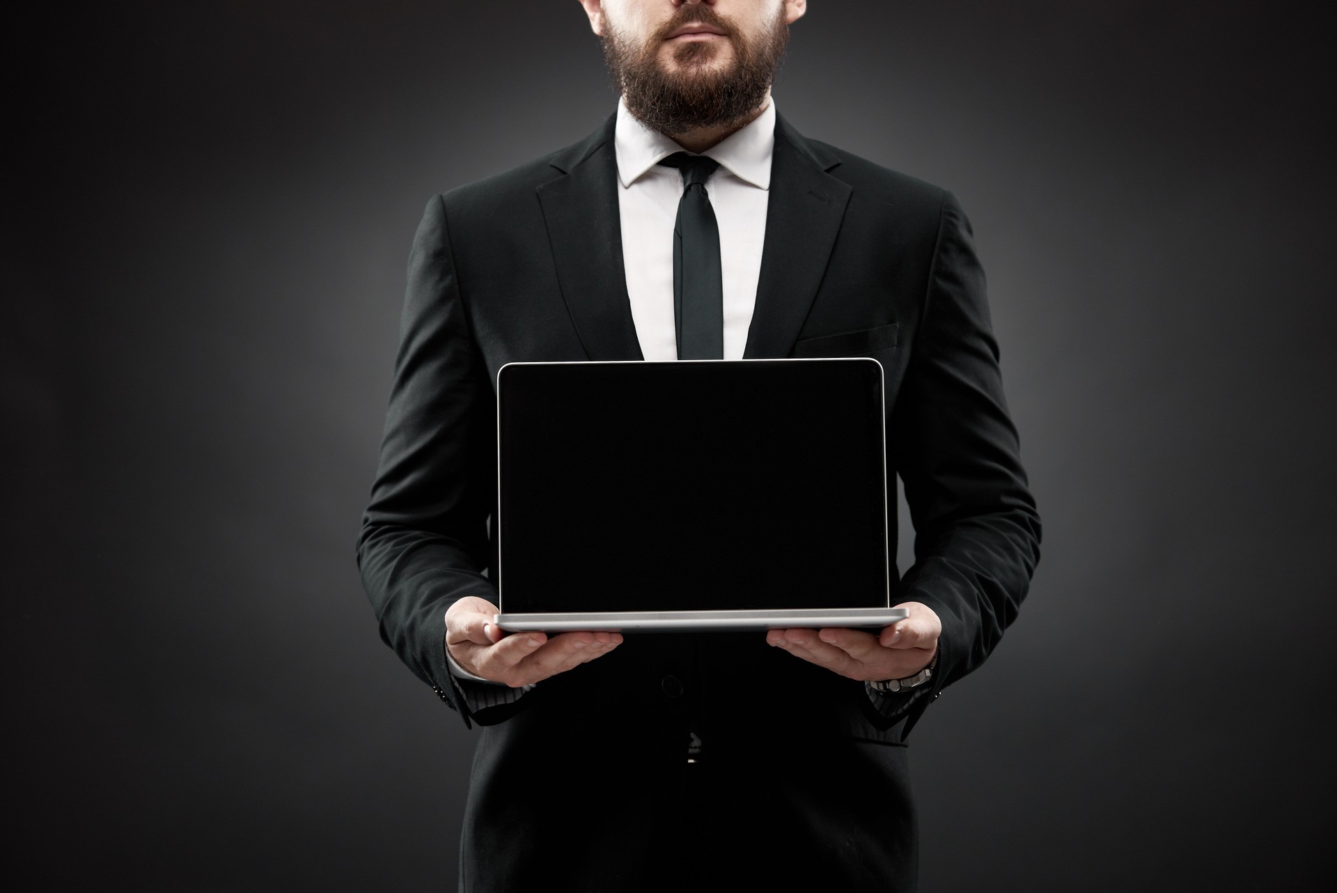 Businessman showing open laptop screen